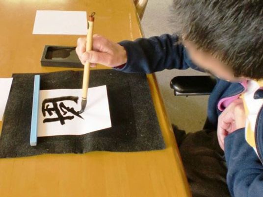 書道をする人の上半身