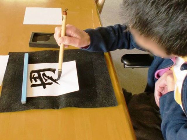 書道をする人の上半身