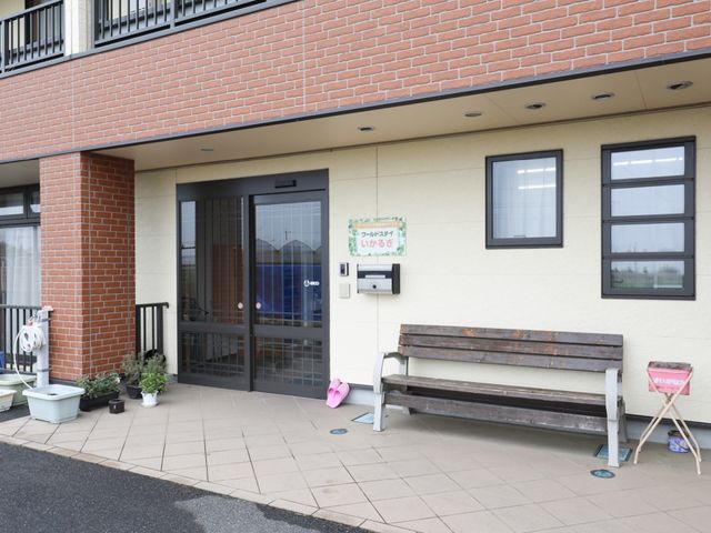 玄関と掲示板のある外観 玄関 明るく開放的なエントランスの様子です。訪れる方々が一息つけるベンチも設置されています。