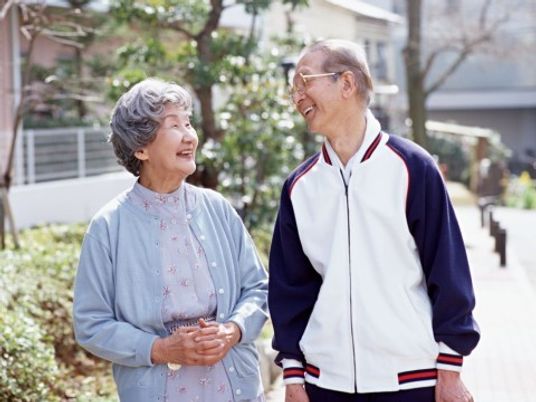 笑顔で歩く高齢の男女