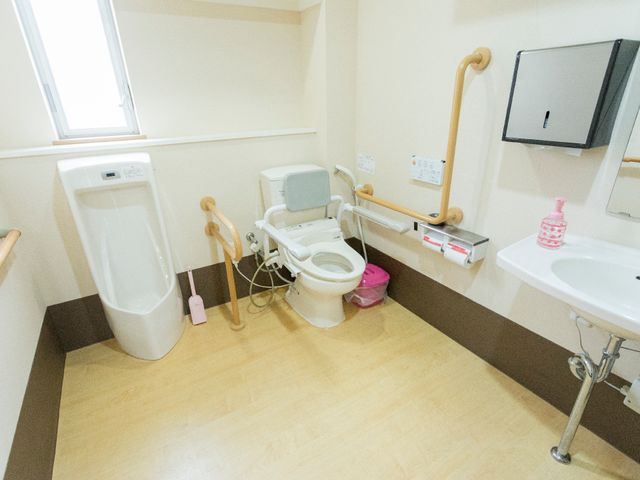 バリアフリー設計のトイレ トイレ 手すりが設けられた広々としたトイレです。清潔感があり使いやすそうな設備が整っており、安心してご利用いただけます。