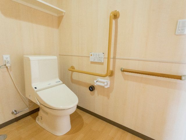 バリアフリー設計のトイレ トイレ 安全に配慮された手すり付きのトイレです。どなたでも使いやすい工夫がされており、安心してお使いいただけます。