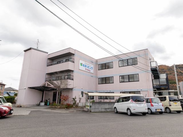 ピンク色の建物外観 外観 ゆったりとした駐車スペースを備え、穏やかな色合いの建物です。周辺環境も静かで、ゆとりある職場環境をお求めの方に適しています。
