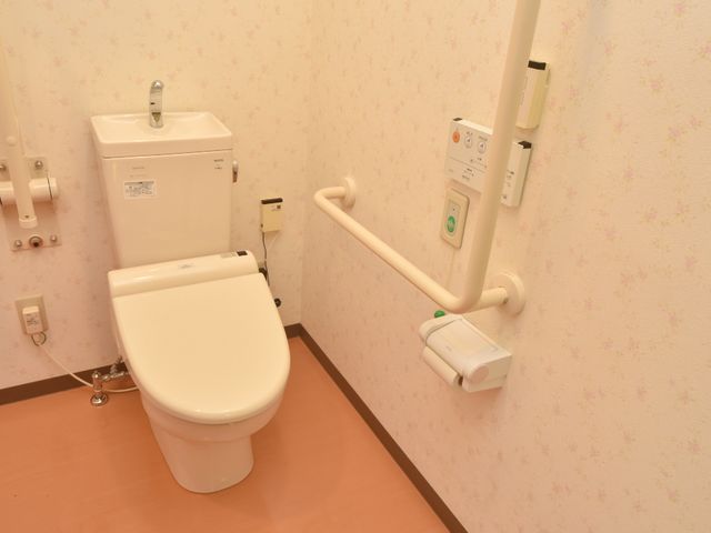 バリアフリーのトイレ設備 手すり付きトイレ 広々とした設計で、サポート用の手すりが設置されたトイレです。サポートが必要な方も安心してご利用いただける環境が整っています。