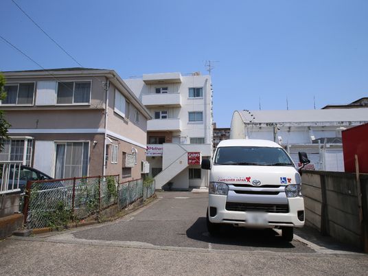 白色の車両と建物外観