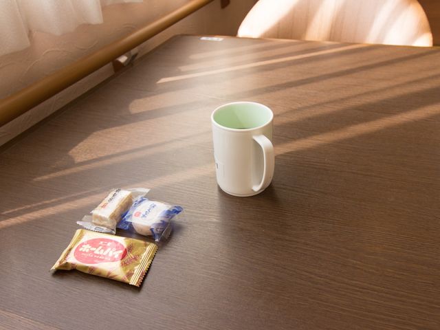テーブル上のカップとお菓子 食堂 日差しが心地よい休憩スペースで、リラックスしながらお茶とお菓子の時間をお過ごしいただけます。