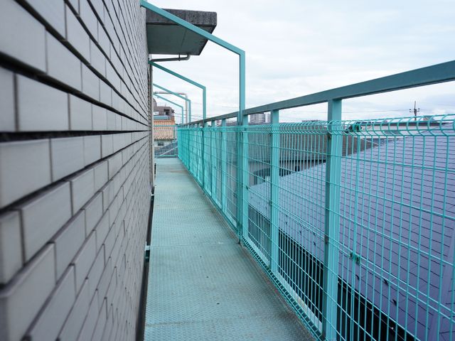 広々としたバルコニー風景 3階には緑色の長くつながったベランダがついていて、いろいろなドアから出ることができる。洗濯物を干す場合もある。" 目の前に開けた眺望を楽しめる、ゆったりとしたバルコニーです。新鮮な空気を感じながら心地よい時間を過ごすことができます。