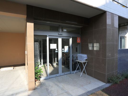 施設入口は自動ドアになっているので、車椅子を利用している方でも安心である。郵便ポストや傘立てもある。
