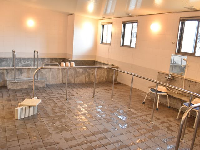 明るい照明の浴室 広々とした大浴場 手すりがついた広々とした浴室です。ご高齢の方も安全にご利用いただける工夫がされています。