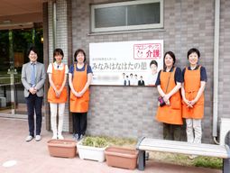 スタッフと看板の前