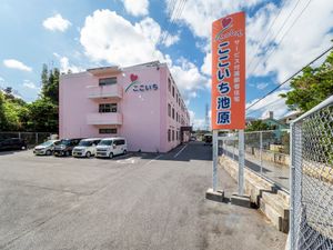 ピンクの建物と駐車場