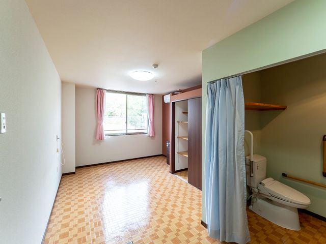 居室のトイレとクローゼット 居室 広々とした個室には、日々の生活を支えるための設備が整っており、窓からは自然光がたっぷりと差し込んでいます。