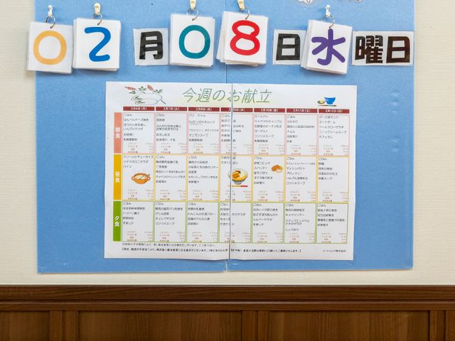 日付と掲示物の壁面 展示物 日々の活動がひと目でわかる壁面の掲示物です。利用者様の生活リズムを支援する工夫がされています。