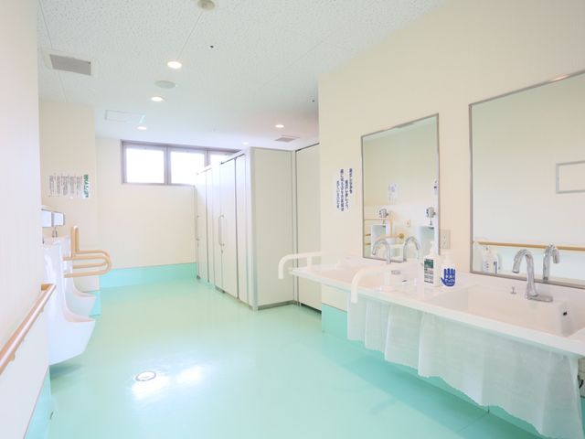 清潔感ある洗面台 トイレ ゆったりとした空間の洗面台は清潔で明るく、快適にお使いいただけます。手すりも設置しており、サポートが必要な方にも配慮されています。