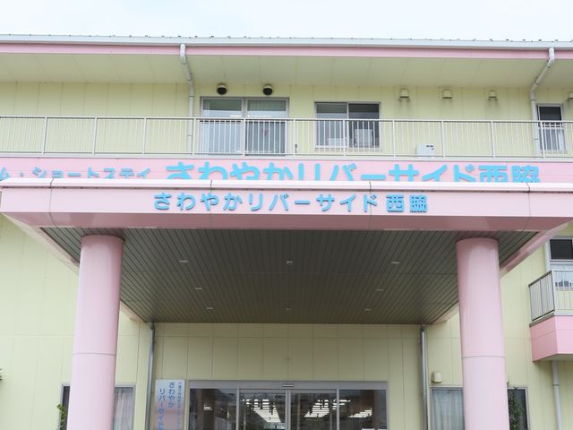 ピンクの建物のエントランス 玄関 清潔感のあるエントランスには、利用者が来訪者を迎える広々としたスペースがあります。興味を持たれた方は、ぜひ一度足を運んでみてください。