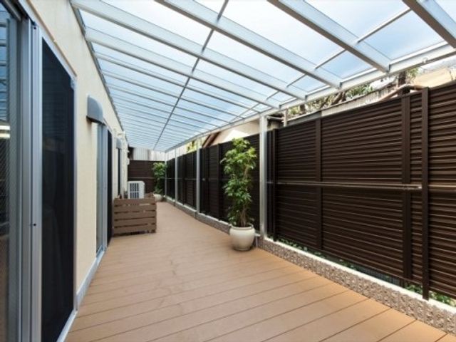 快適な中庭の通路 ウッドデッキ ゆったりとした通路はガラス屋根で覆われ、雨の日も安心して散歩を楽しめます。周りは緑に囲まれ、癒しの空間が広がっています。