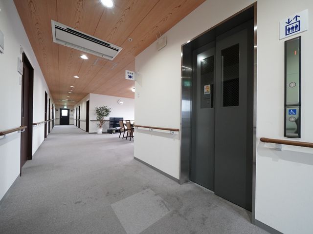 明るい木目調の廊下 廊下 清潔感溢れる廊下は、手すりが整備されており歩行に安心感を与えます。天井は高く、開放的な雰囲気で快適です。