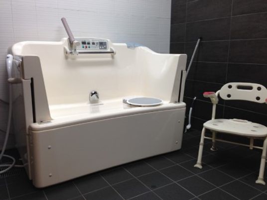 自立サポート入浴のできる機械浴槽が設置されている。座位からスムーズに浴槽に入れるように、傍にはシャワーチェアが置かれている。