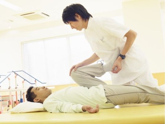 リハビリ中の患者と職員