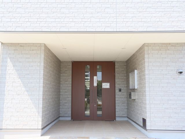 明るいエントランスの外観 エントランス さわやかな印象のエントランスです。入口には案内看板があり、訪れる方々を温かく迎え入れます。