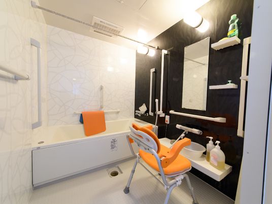 白と黒を基調としたスタイリッシュで清潔感がある浴室。広々とした浴槽と洗い場が設けられている。緊急な場合の通報装置が設置されている。
