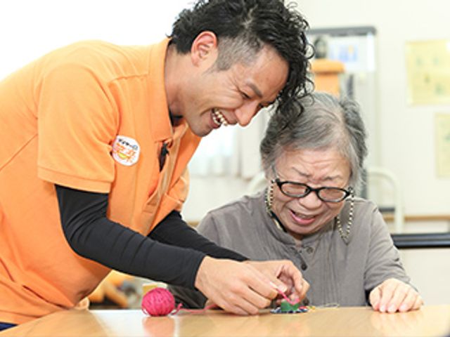 笑顔で支援するスタッフ 笑顔のスタッフが手作業での支援を行っており、あたたかい雰囲気の中、利用者様が楽しみながら活動しています。