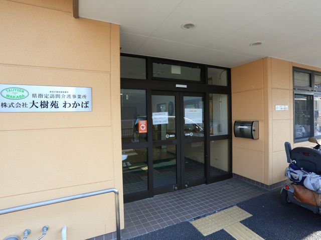 エントランスの自動ガラス戸 玄関 車椅子が停まっている明るいエントランスは、ご来所されるすべての方が気持ちよくお越しいただけるようになっています。