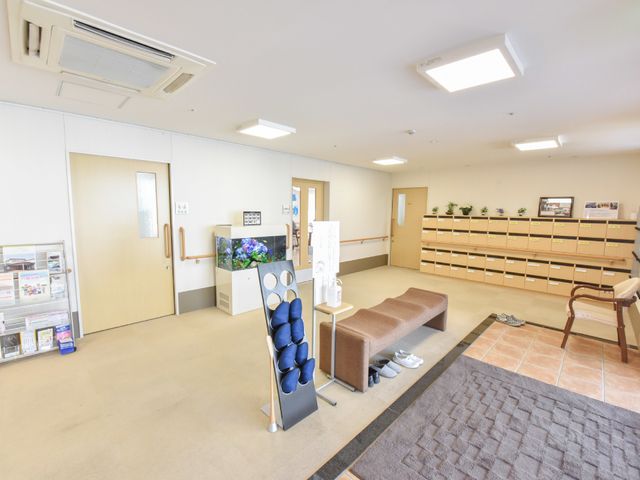 広々とした明るいロビー 玄関4 ゆったりとした快適な空間のロビーでは、来訪者の方々を暖かく迎え入れることができます。応接用の椅子も完備し、安心してご利用いただけます。