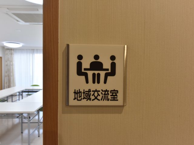 共有スペース案内表示 地域交流室 清潔感のあふれる共有スペース案内が目に留まります。活気ある日々を過ごせる場所として、様々な用途に対応しています。