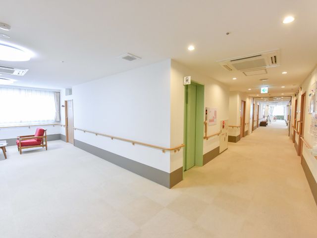 明るい廊下の風景 エレベーター 手すり付きの広々とした廊下は、落ち着いた色合いで、安心して歩行できる工夫がされています。
