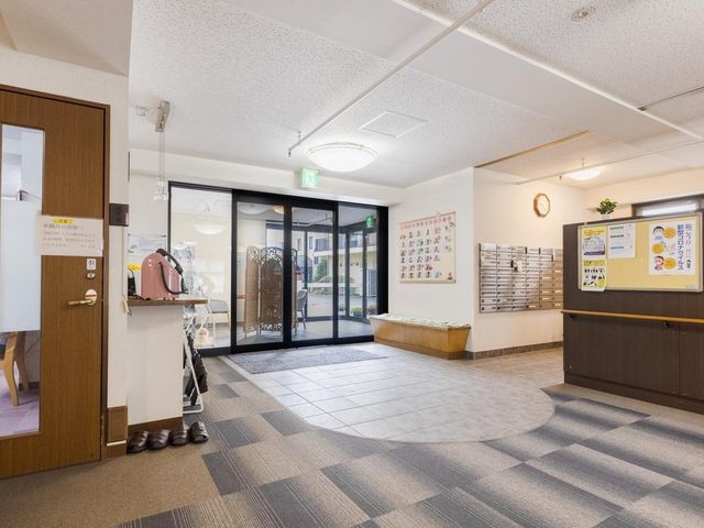 居室の明るい空間 エントランス ゆったりとした空間で配置されたベッドが印象的な居室で、静かで落ち着いた環境での仕事が可能です。窓から自然光が入り、居心地の良さを感じられる作りになっています。