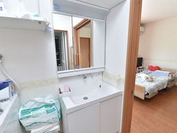 居室の洗面台とベッド