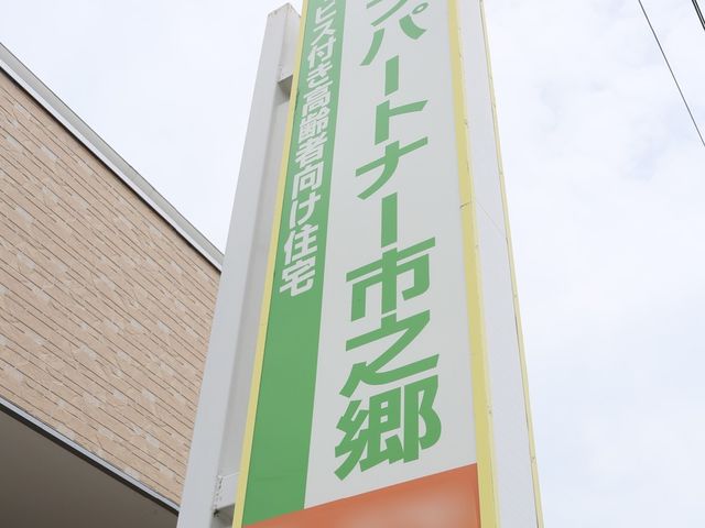 縦長の看板 設備 緑とオレンジ色が目を引く看板が、明るい未来への一歩をお知らせします。ここから新しい職場の第一歩を踏み出しませんか。