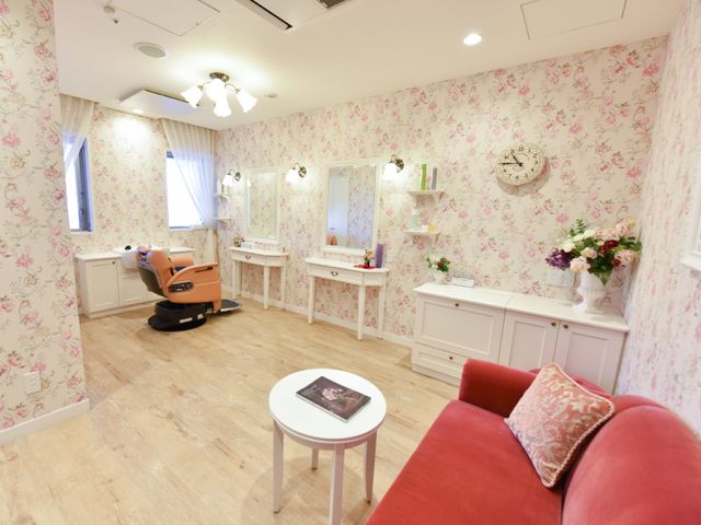 理美容室の明るい内観 ビューティーサロン 花柄の壁紙が印象的な落ち着ける空間で、身だしなみのお手入れが気軽にできる環境です。