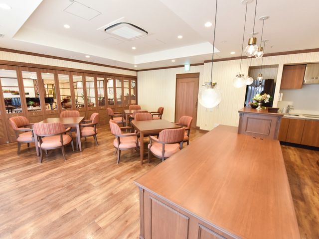 広々としたダイニングルーム カフェサロン 木目調の家具が温かみを感じさせる食堂です。共有スペースでは、ゆったりと食事や交流が楽しめそうです。