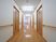 木目調がくっきりと出ている、光沢のある明るい床の廊下がある。両サイドには入居者様の居室のドアが並んでいる。