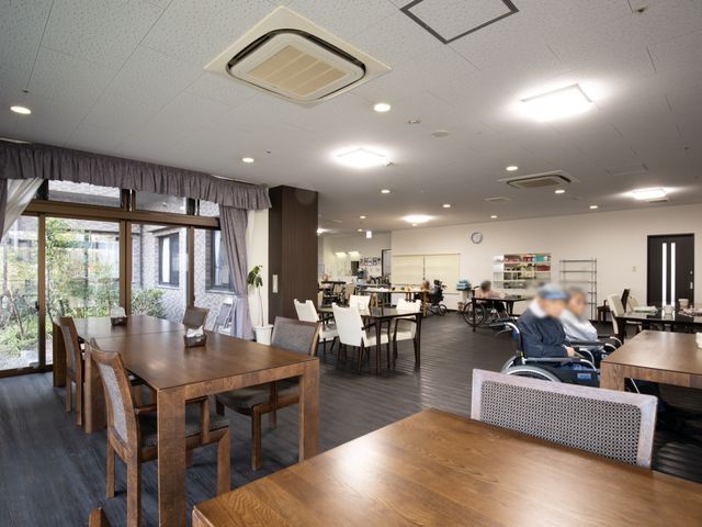 広々した明るい食堂空間 食堂 開放感のあふれるダイニングで利用者が食事を楽しんでいます。職員とのコミュニケーションも活発そうです。
