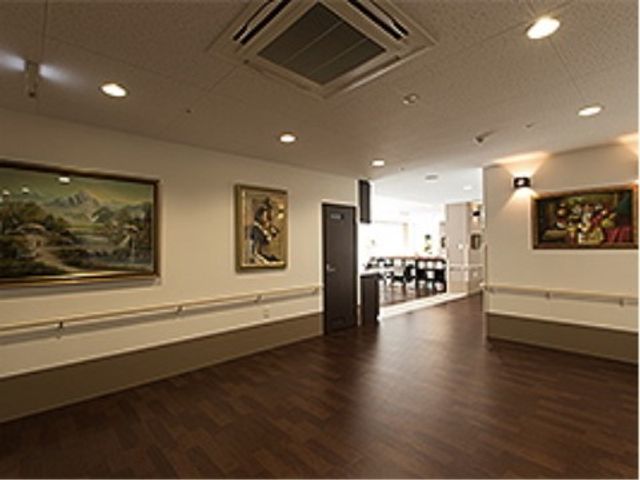 清潔感ある廊下の様子 エレベーターホール 手すりが完備された床暖房の廊下です。壁に飾られた絵画を眺めながら、ゆったりと散策をお楽しみいただけます。