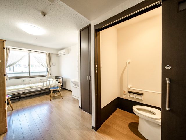 居室のベッドとトイレ 居室 採光豊かな居室で、生活しやすい設計です。安全に配慮したトイレ設備が整っています。