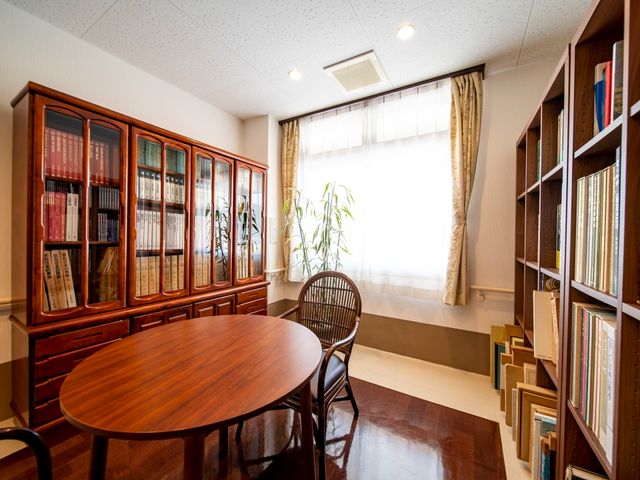 本棚と円卓のある部屋 談話室 落ち着いた雰囲気の読書スペースです。ゆったりとした時間を過ごせる環境が整っています。
