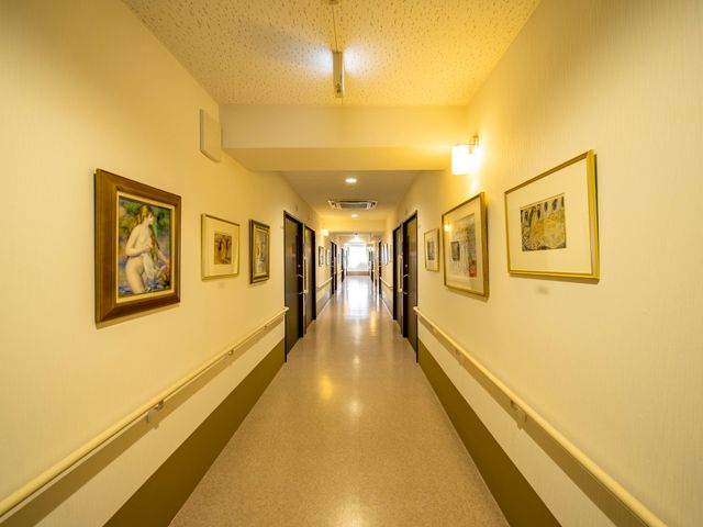 廊下に絵画を飾った空間 通路 壁には絵画が飾られ、落ち着いた雰囲気のある通路です。明るく清潔感のある環境で、快適な勤務が期待できます。