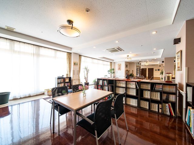 快適な共有スペース 談話室 落ち着いた色合いの居心地の良い空間です。読書や会話を楽しむための椅子とテーブルが備えられています。