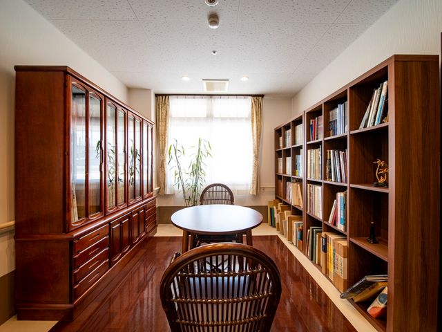 本棚とテーブルのある部屋 談話室 ゆったりと読書が楽しめる、穏やかな雰囲気の空間です。