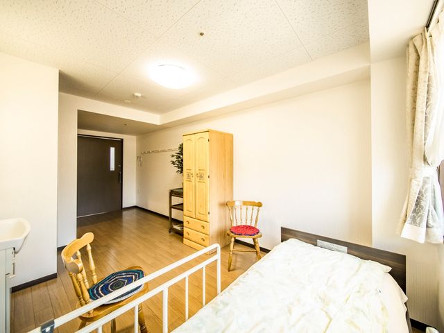 明るい居室の様子 居室 広々と清潔感のある空間に、暖かみのある木製家具が配置されています。
