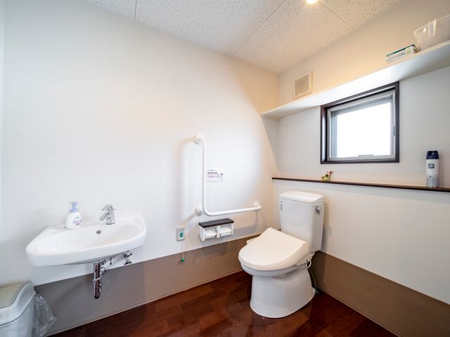 清潔なトイレ空間 トイレ 手すりの整った清潔で広々としたトイレです。使いやすさに工夫が見られます。