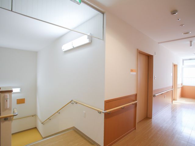 手すり付きの廊下 通路 手すりが整備された廊下を通り、安全にくつろげる環境です。ここでのお仕事は、居心地の良い空間を提供することにつながります。