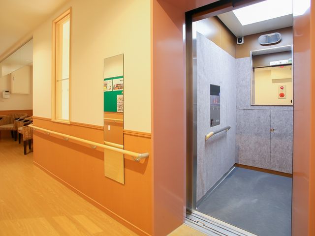 手すり付き廊下とエレベーター エレベーター 手すりが設置された温かみのある廊下は、ご利用者様の移動を支えます。安全に配慮されたエレベーターも完備しております。