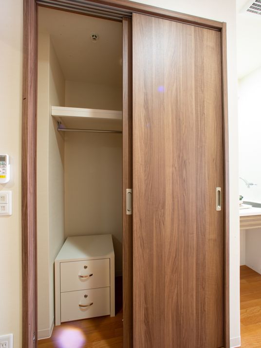 茶色い扉の開いたクローゼット