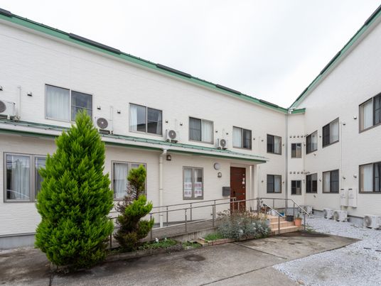 白い壁の建物と緑の庭