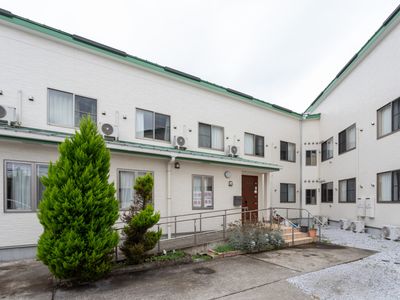 白い壁の建物と緑の庭